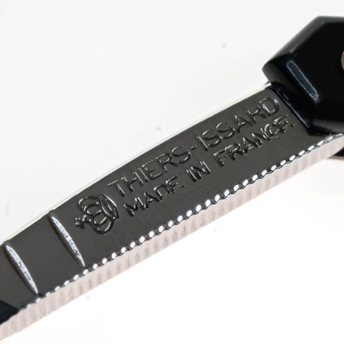 Brzytwa Thiers Issard Special Coiffeur Black 6/8 z widocznym ostrzem i czarną rączką, ostrze ozdobione napisem „THIERS-ISSAHD MADE IN FRANCE”. Zbliżenie na detale ostrza i rączki na białym tle podkreślającym stal.