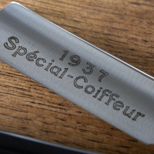 Brzytwa Thiers Issard Special Coiffeur w zbliżeniu, z widocznym logo Spécial-Coiffeur oraz rokiem 1937 na stalowej powierzchni, umieszczona na drewnianym tle.