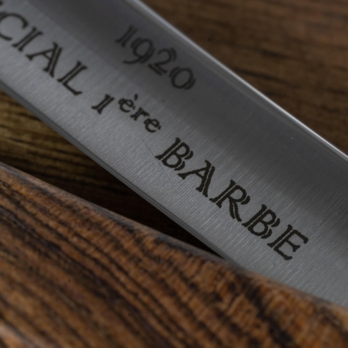 Brzytwa Thiers Issard Special 1ère Barbe 4/8 z stalowym ostrzem oznaczonym SPECIAL 1ère BARBE 1920 i rączką z drewna bocote o ciepłej fakturze, z detalicznym ujęciem na tle naturalnego drewna.