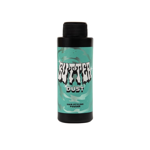 Puder do włosów w czarnej butelce z turkusowym nadrukiem, z dużym napisem BUTTER DUST w stylu retro i mniejszym HAIR STYLING POWDER. Ujęcie frontalne, butelka stoi na płaskiej powierzchni.