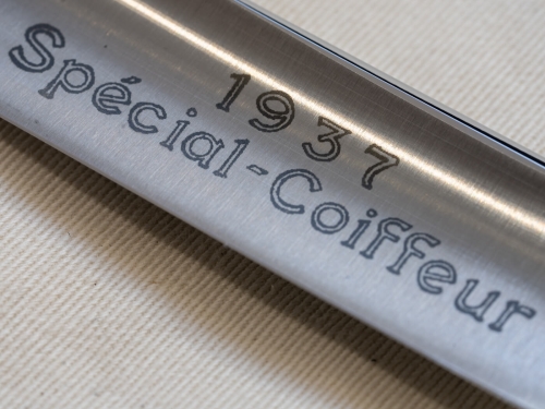 Brzytwa Thiers Issard Special Coiffeur 6/8 w ujęciu zbliżeniowym, ukazująca polerowane ostrze ze wytłoczonym napisem „Spécial-Coiffeur 1937” w eleganckim stylu. Ostrze wykończone w matowym srebrze, leży na jasnym tle.
