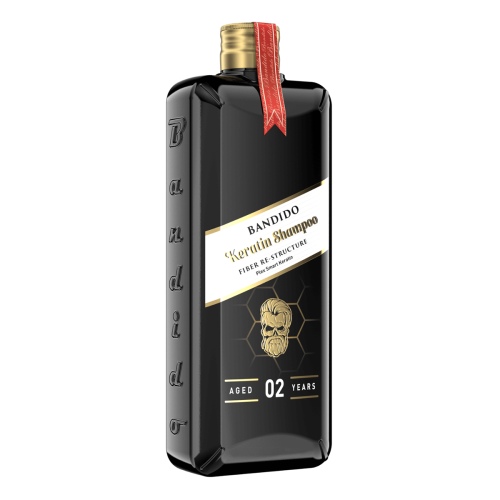 Czarny szampon Bandido 350 ml w prostokątnej butelce z teksturowanym wykończeniem, złotym korkiem, czerwoną wstążką i złotymi detalami, oznaczony AGED 02 YEARS.