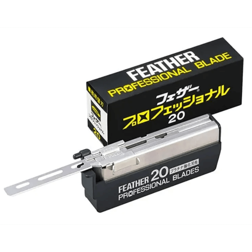 Żyletki Feather Professional Blade PB-20 w opakowaniu, widok frontalny. Metalowy element z wytłoczeniem na środku; pudełko czarne z żółtym napisem „FEATHER PROFESSIONAL BLADE” oraz symbolem w japońskim stylu. W zestawie 20 żylet.