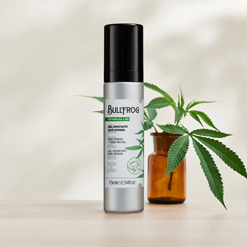 Nawilżający żelowy krem Bullfrog 75 ml w srebrnym cylindrycznym opakowaniu z czarną zakrętką, etykieta „Botanical Lab” i „Anti-Stress” z zielonym liściem, na drewnianej powierzchni przy brązowym słoiku i liściach roślin.