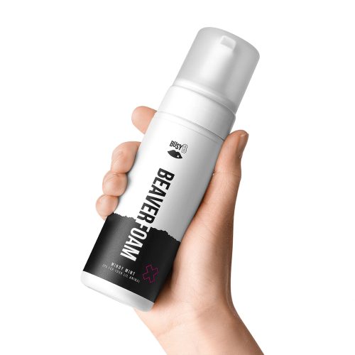 Chłodząca pianka intymna Mindy Mint 150 ml w białym, okrągłym opakowaniu z czarnymi i różowymi akcentami, z napisem BEAVER FOAM. Pojemnik z nakrętką trzymany w dłoni na jasnym tle.