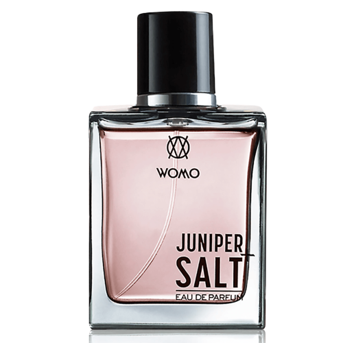 Butelka perfum WOMO Juniper+Salt 100 ml, prostokątna, przezroczysta, z różowym płynem. Tłoczone logo WOMO u góry, nazwa JUNIPER SALT czarnymi literami na dole, czarna zakrętka, na białym tle.
