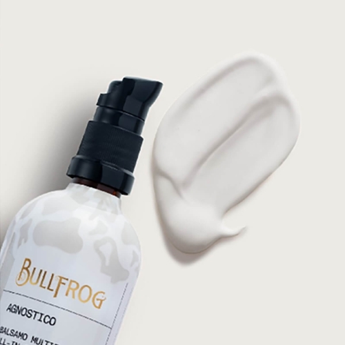 Balsam multifunkcyjny Bullfrog Agnostico 100 ml z czarną pompką. Butelka z minimalistycznym designem i etykietą. Obok widoczna biała konsystencja balsamu na jasnym tle.
