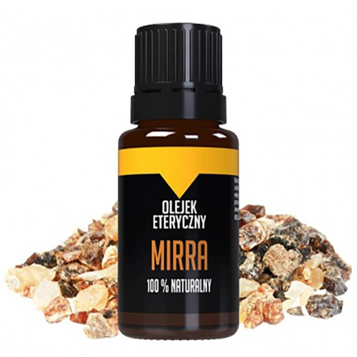Olejek eteryczny mirra 10 ml w brązowej butelce z czarną zakrętką, na etykiecie widoczne napisy „OLEJEK ETERYCZNY”, „MIRRA” oraz „100% NATURALNY”. Butelka umieszczona na tle różnokolorowych kawałków żywicy. Ujęcie frontalne, butelka stoi na złożonym tle.