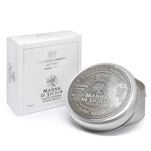 Mydło do golenia Saponificio Varesino Manna di Sicilia 150g w srebrnej puszce obok białego opakowania. Widoczne napisy Manna di Sicilia, Shaving Soap i logo. Okrągłe, z błyszczącą powierzchnią na jasnym tle.