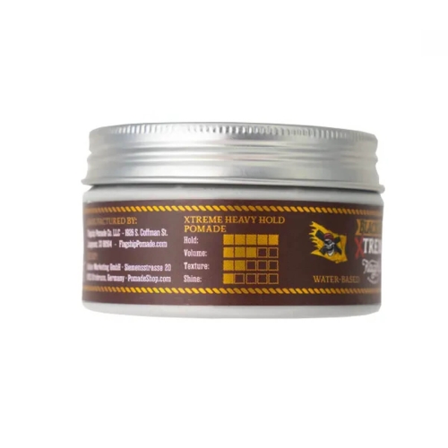 Metalowy słoik z wodną pomadą do włosów, brązowa etykieta z napisem XTREME HEAVY HOLD POMADE oraz oznaczeniami trzymania, objętości, tekstury i połysku. Słoik leży pod kątem na białym tle.