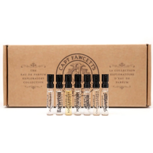 Zestaw 7 próbników perfum Captain Fawcett EDP Exploratory Collection w przezroczystych flakonikach z atomizerami i czarnymi koreczkami, ustawionych w linii. W tle brązowe opakowanie z logo marki, na białym tle.