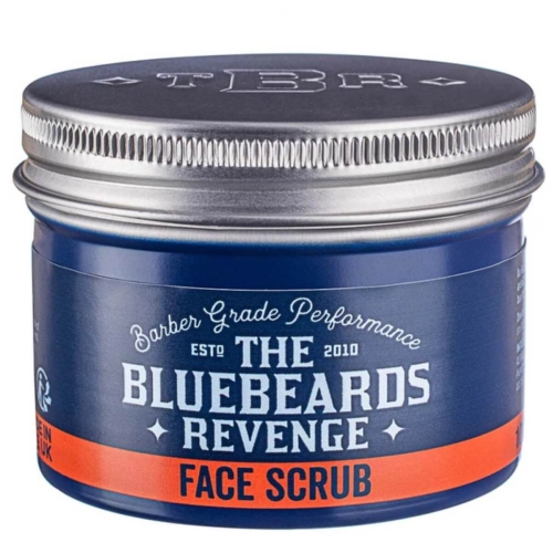 Niebieskie, okrągłe opakowanie peelingu do twarzy THE BLUEBEARDS REVENGE FACE SCRUB z metalową zakrętką i pomarańczowym paskiem z informacjami, ukazane z boku w lekkim zbliżeniu, pokazujące teksturę i etykietę.