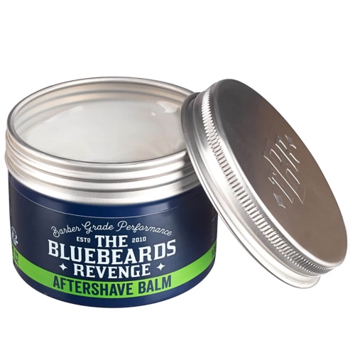 Balsam po goleniu The Bluebeards Revenge w niebieskiej metalowej puszce z zielonym paskiem, częściowo otwartej, z widoczną białą konsystencją. Etykieta zawiera napisy „THE BLUEBEARDS REVENGE” i „AFTERSHAVE BALM”.