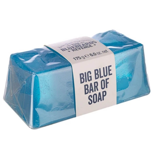 Błyszczące mydło w kostce w błękitnym kolorze o wymiarach 175 g z etykieta BIG BLUE BAR OF SOAP widoczną na białym tle, leżące na stole pod kątem.