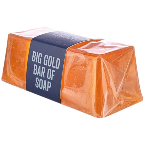 Mydło w kolorze przezroczystym pomarańczowym, w formie dużej kostki, z widoczną niebieską etykietą zawierającą napis BIG GOLD BAR OF SOAP. Produkt leży na płaskiej powierzchni, ukazując swoje gładkie, połyskujące boki.