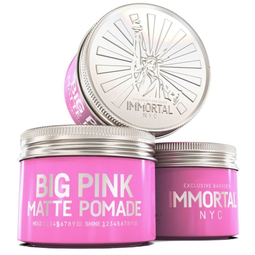 Różowa matowa pomada do włosów w metalowym słoiku 100 ml z napisem BIG PINK MATTE POMADE oraz logo IMMORTAL NYC i grafiką Statuy Wolności na pokrywie, na neutralnym tle podkreślającym kolor.