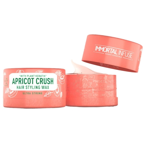 Jasnopomarańczowa pomada woskowa do włosów w okrągłym opakowaniu, z otwartą pokrywką i widocznym woskiem. Etykieta z napisem APRICO CRUSH HAIR STYLING WAX i WITH PLANT KERATIN na jasnym tle.