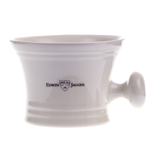 Biała ceramiczna filiżanka do golenia, lekko stożkowata, z delikatnymi rowkami i czarnym napisem 'EDWIN JAGGER' na boku. Zaokrąglony uchwyt, proste tło podkreśla elegancję.