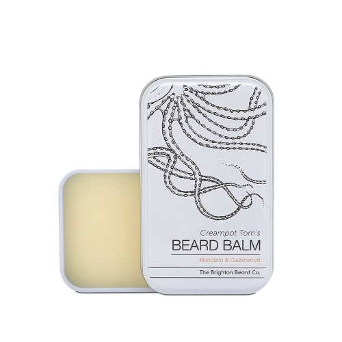 Biała metalowa puszka z wyjmowanym wieczkiem ze szkicem węży i napisem Creampot Tom’s BEARD BALM, aromat Mandarin & Cedarwood. Puszkę pokazano otwartą na jasnym tle.