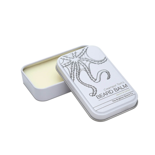Biała metalowa puszka balsamu do brody, otwarta, z żółtą zawartością. Na wieczku grafika ośmiornicy oraz napisy: Creampot Tom's BEARD BALM i Jasmin & Lemon.