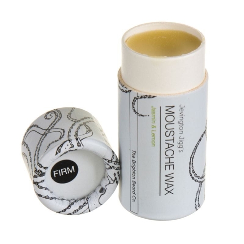 Wosk do wąsów w cylindrycznym opakowaniu z białą pokrywką i szaro-zieloną etykietą z ośmiornicą. Napis MOUSTACHE WAX i Jasmin & Lemon, otwarte opakowanie z widocznym woskiem. FIRM na spodzie pokrywki.