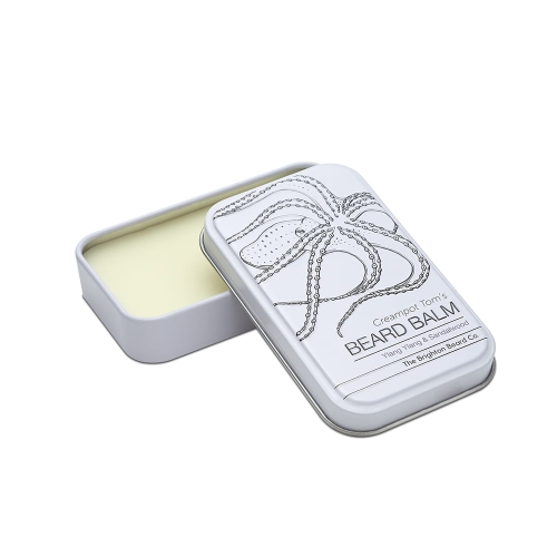 Biały metalowy pojemnik na balsam do brody z żółtawą maścią, otwartą pokrywką, rysunkiem ośmiornicy i napisem Creampot Tom's BEARD BALM. Wielkość kieszonkowa.