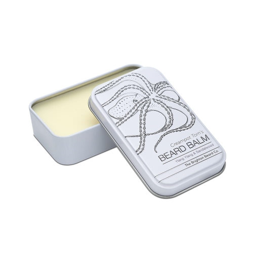 Biały, matowy, prostokątny pojemnik na balsam do brody, otwarty z jasną zawartością. Na wieczku czarny kontur ośmiornicy i napis Creampot Tom's BEARD BALM. Pojemnik stoi na jednolitym tle.