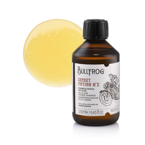 Brązowa butelka z czarną zakrętką, zawierająca żółty płyn. Etykieta z logo Bullfrog i napisem SECRET POTION N°2, wielofunkcyjny szampon do ciała i włosów. Butelka stoi na białym tle obok kuli z żółtym płynem.