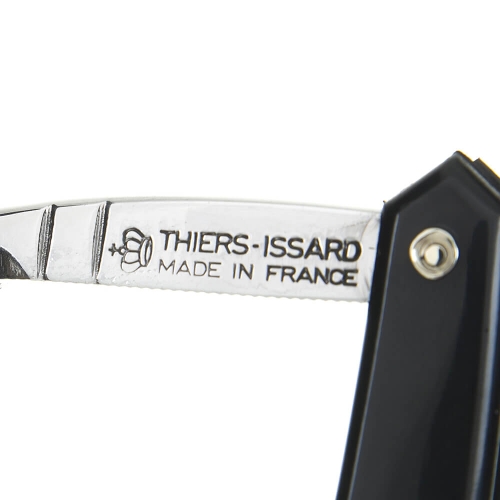Metaliczne ostrze brzytwy THIERS-ISSARD z napisem MADE IN FRANCE, zbliżenie na połyskujące ostrze i czarną rączkę.