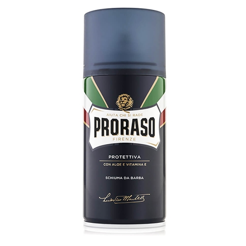 Pojemnik z pianką do golenia Proraso 300 ml, granatowy z białymi, czerwonymi i zielonymi akcentami. Napisy: PRORASO, FIRENZE, PROTETTIVA, składniki: aloes i witamina E. Stoi pionowo na białym tle.