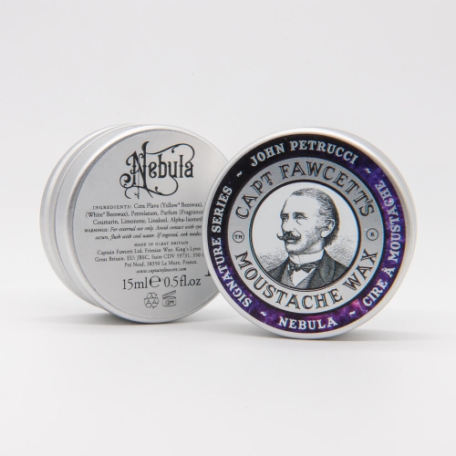 Srebrne opakowanie pasty do wąsów z fioletowym akcentem, z wizerunkiem mężczyzny i napisem CAPT. FAWCETT'S MOUSTACHE WAX NEBULA. Z tyłu skład i instrukcje, przeznaczona do stylizacji wąsów.