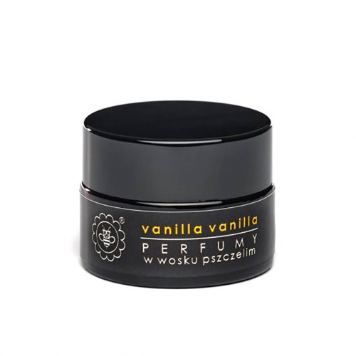 Czarny słoiczek z wieczkiem, logo z pszczołą, tekst vanilla vanilla i PERFUMY w wosku pszczelim w złotym i białym kolorze, widok frontalny. Słoiczek stoi na płaskiej powierzchni z jednolitym tłem.