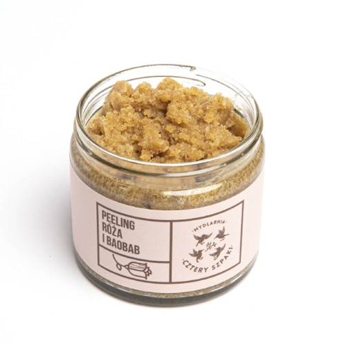 Peeling w przezroczystym szklanym słoiku z brązowym, ziarnistym produktem. Na białym tle z różową etykietą Peeling Róża i Baobab oraz graficznymi elementami. Kremowo-ziarnista konsystencja widoczna z przodu.
