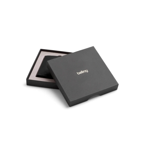 Czarna pudełko z logo bellroy, otwarte, z widoczną w środku przekładką. Pudełko ma minimalistyczny design i gładką fakturę, umieszczone na jasnym tle.